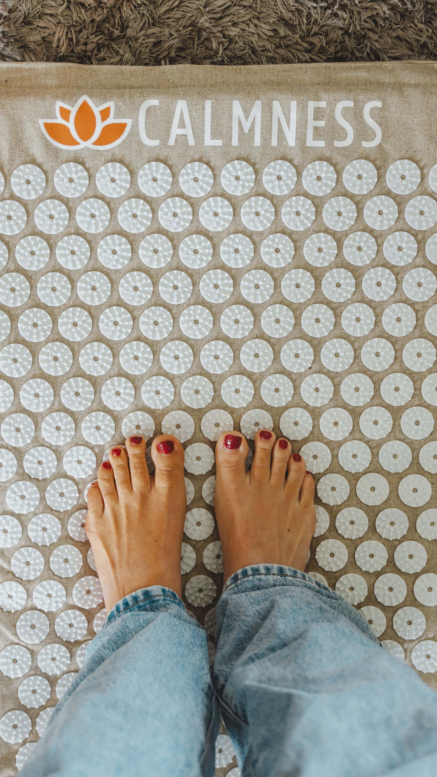 Anne van de Kerkhof standing on the Calmness Eco Acupressure Mat to relax her feet and improve blood circulation